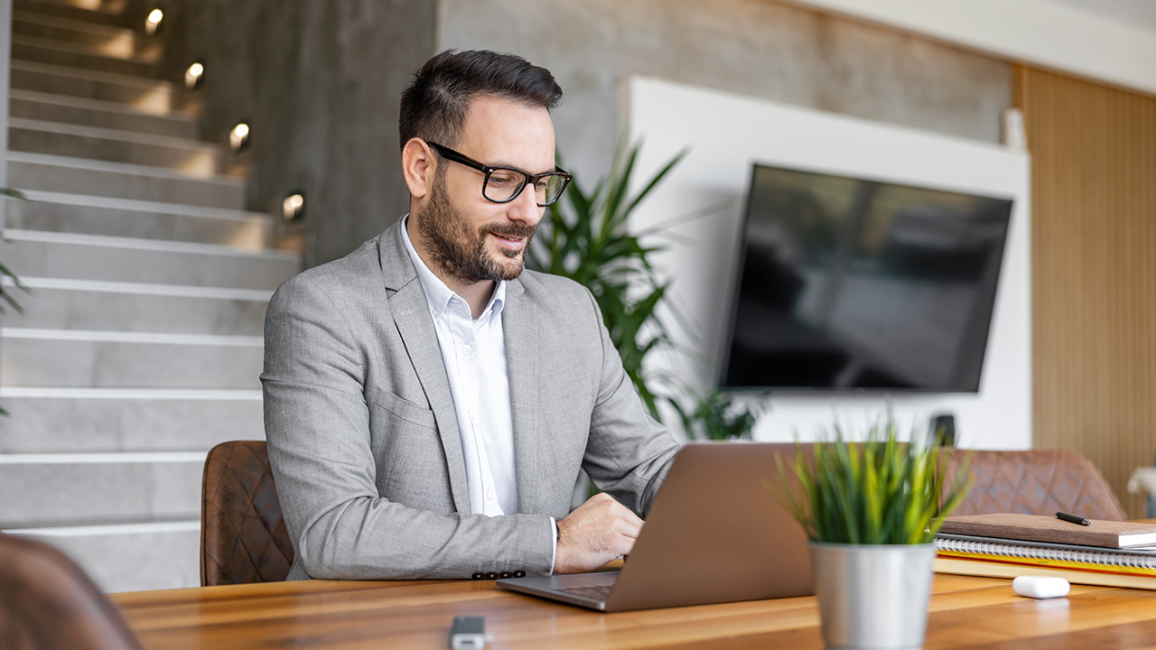 Focused professional working on a laptop, representing strategies on how to optimize time for increased productivity and freedom.