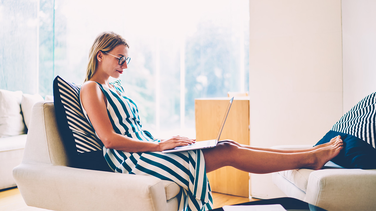 Woman working from home on her laptop, representing the focus and discipline behind the 7 habits that built my 7 figure coaching brand.