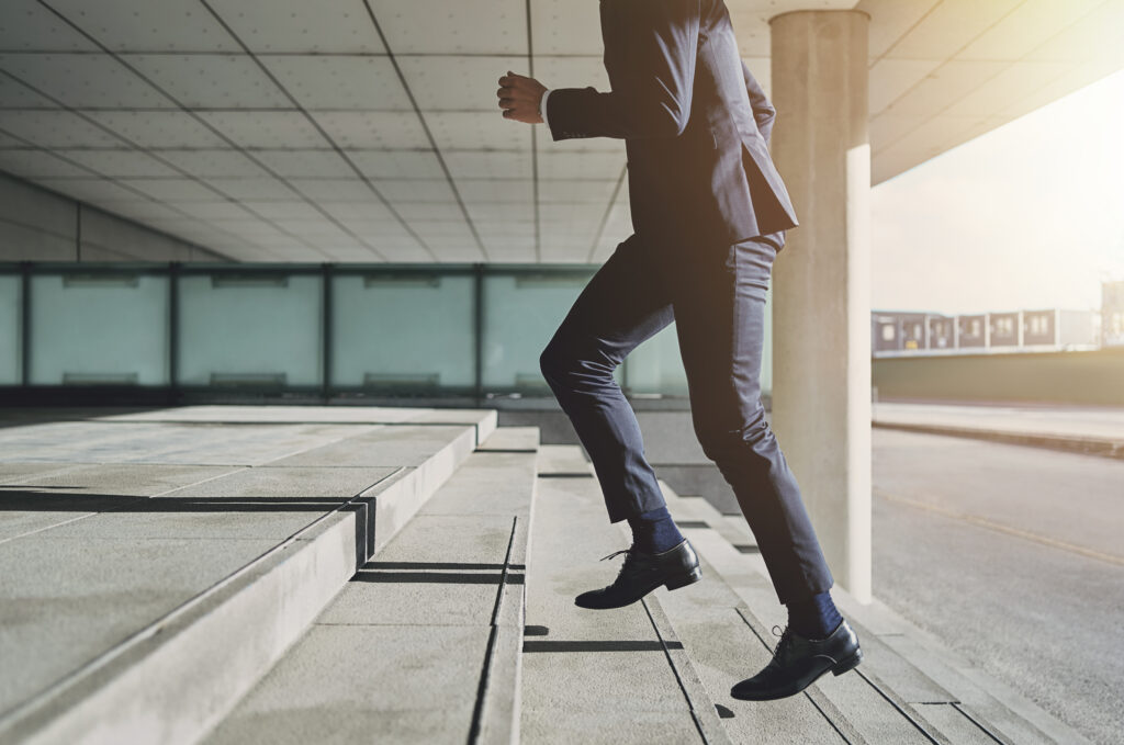 Business professional running up stairs, symbolizing determination and progress—capturing the essence of how to stay motivated in pursuit of success.