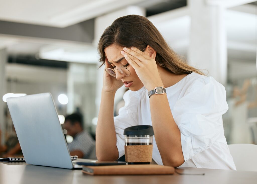 Frustrated Woman Sitting at a Desk with Her Laptop Realizing That Lasting Results Require Building a Strong High Performance Identity