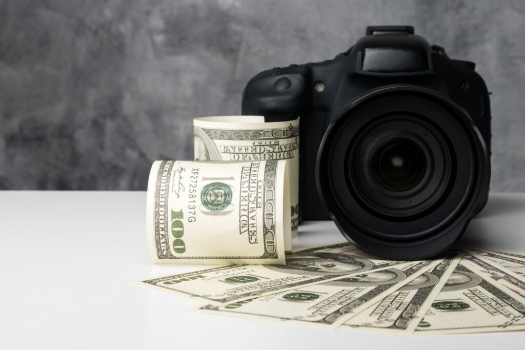 Camera surrounded by hundred-dollar bills symbolizing how SEO services for photographers increase bookings and profitability.
