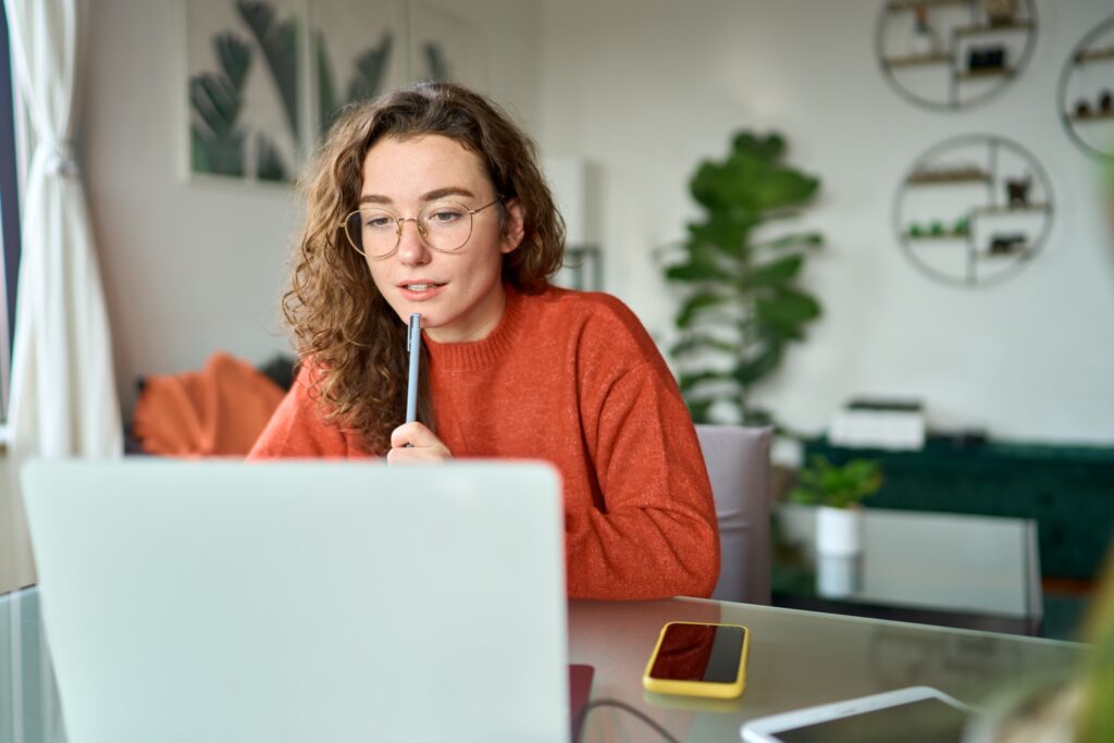 Focused Woman Attending a Virtual Coaching Session Representing Personal Development and Growth Through High Performance Training