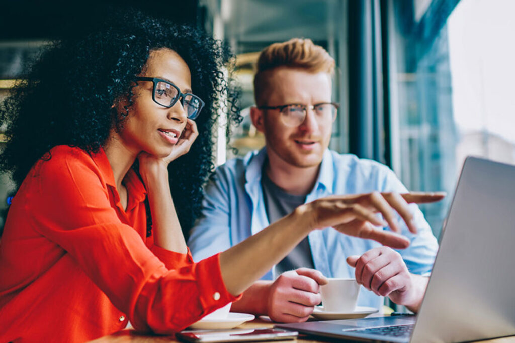 Two professionals discussing goals and strategy over coffee, illustrating how to find a life coach that actually transforms your future through clarity and action planning.