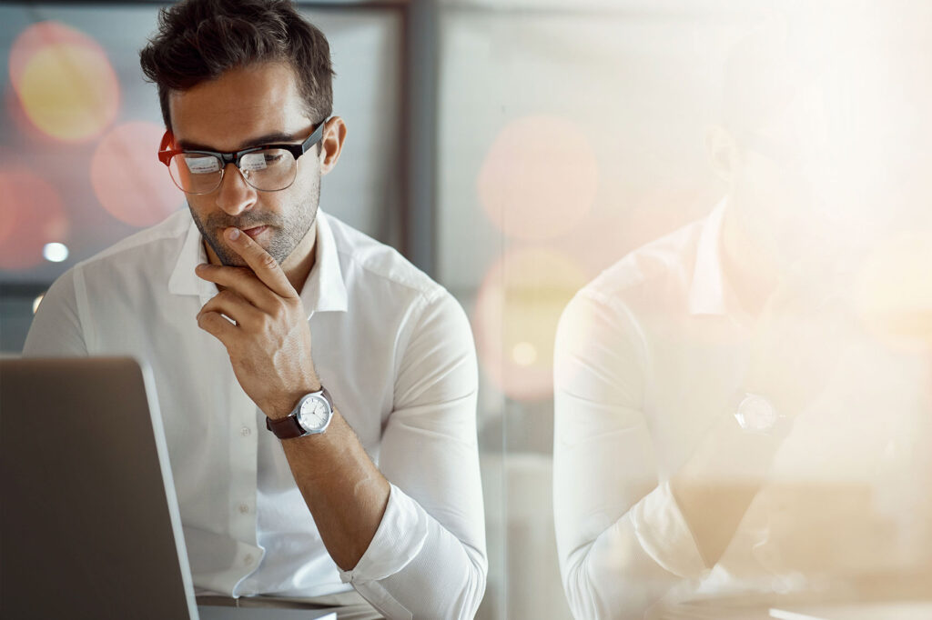 Focused professional deep in thought while working on a laptop, symbolizing reflection and awareness—key signs you’re ready for high performance coaching.